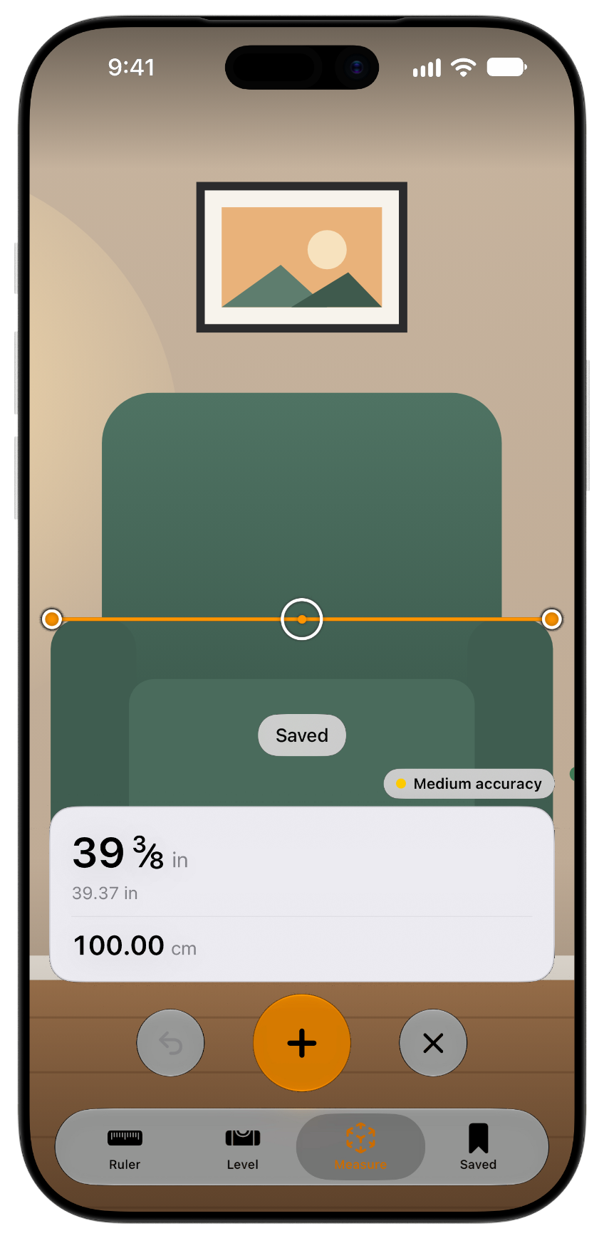 Measure's camera tape measure on an iPhone showing an armchair measured at 39 3/8 inches, or 100.00 centimetres.